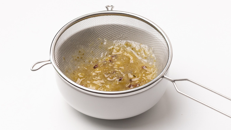 straining gooseberry syrup through sieve