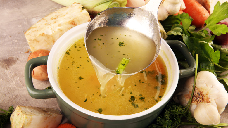 ladling out of a bowl of homemade stock