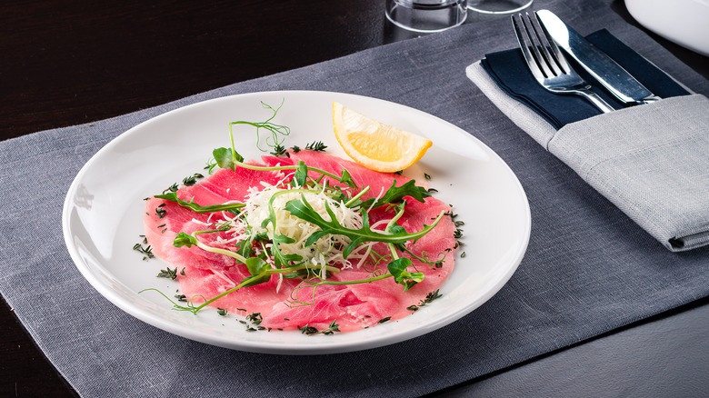 tuna carpaccio on plate with lemon