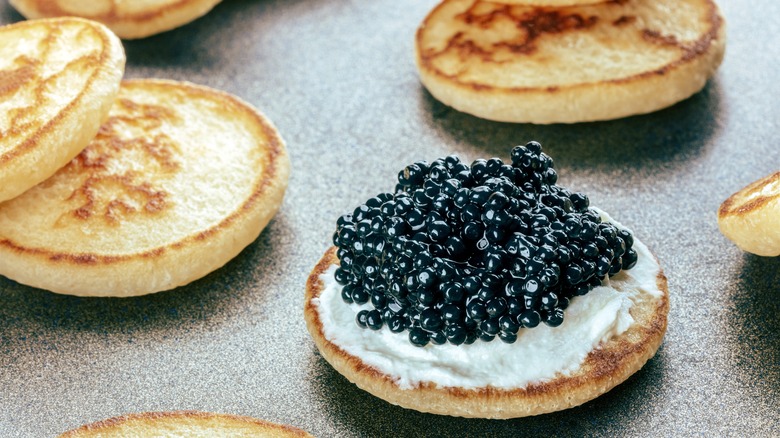 Caviar sits atop a blini with crème fraîche