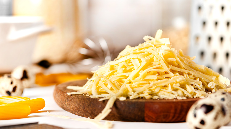 Grated cheese on chopping board