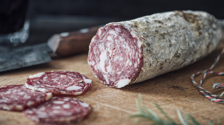 salami sitting on wooden cutting board