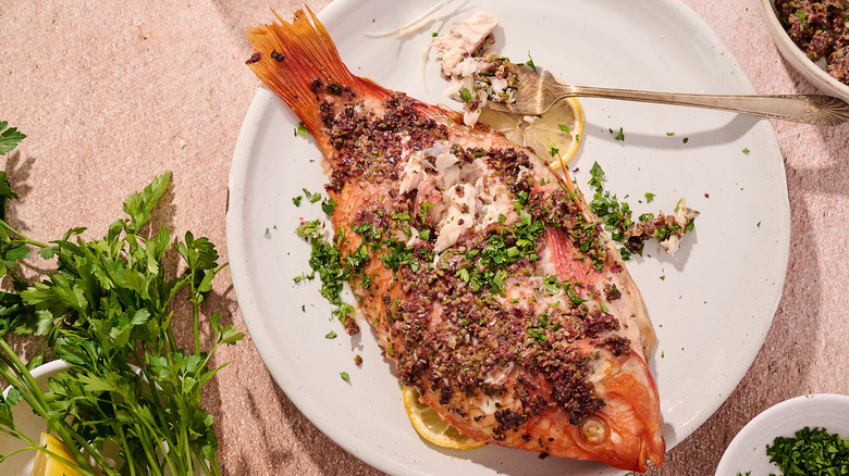 baked tilapia with fork on plate