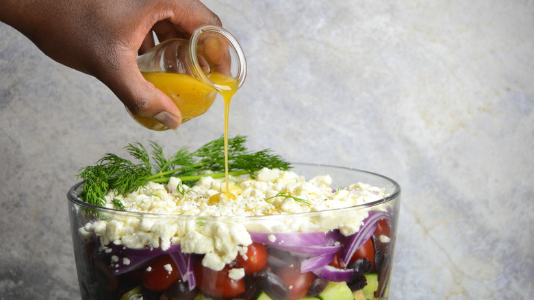 pouring dressing over salad