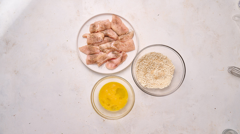 bowls with egg, panko, and chicken on table