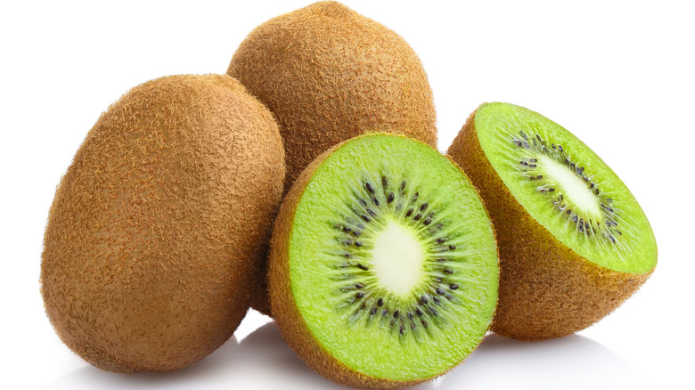 green kiwi fruit whole and cut