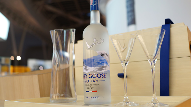 grey goose bottle next to cocktail glasses