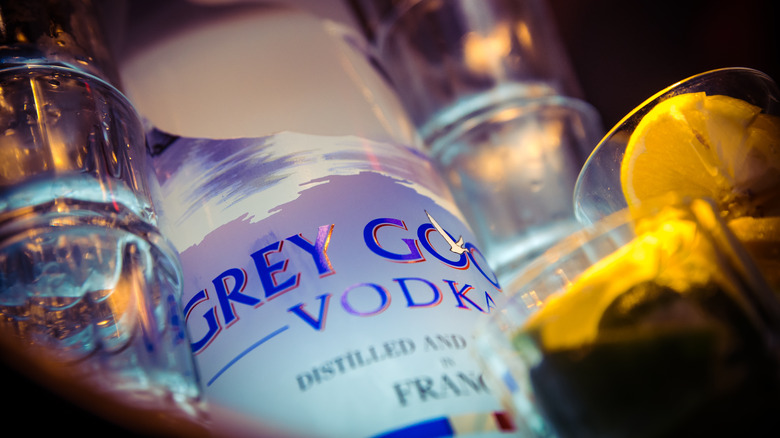 close up of Grey Goose bottle surrounded by glasses