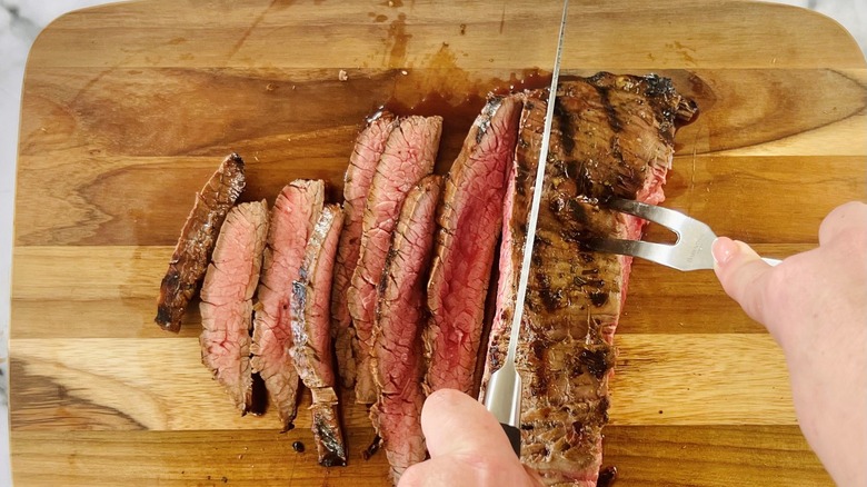 slicing flank steak on board