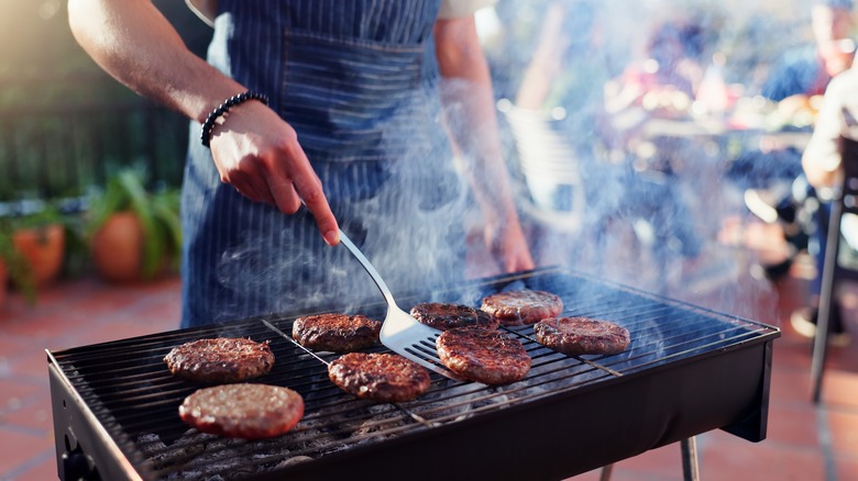 person flipping barbecues on an outdoor grill