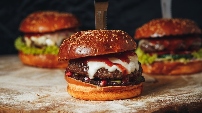 burgers with different toppings on wood 