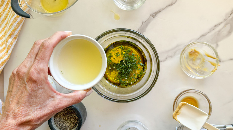 hand adding lemon juice to bowl