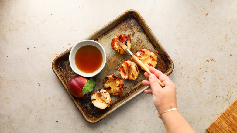 Brushing grilled nectarines with syrup