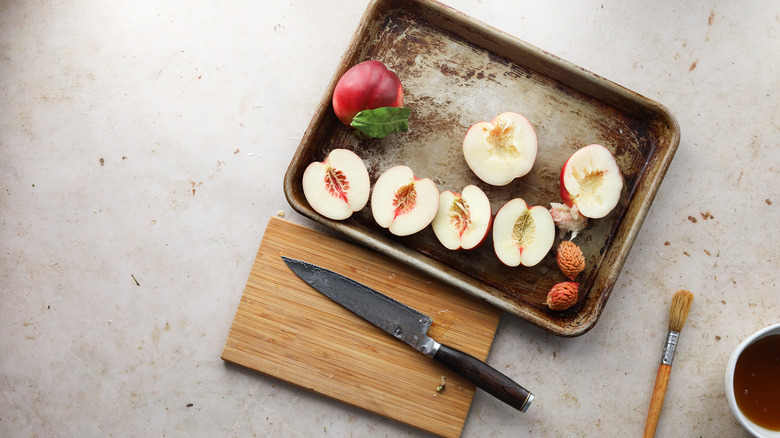 Halved nectarines on rimmed sheet