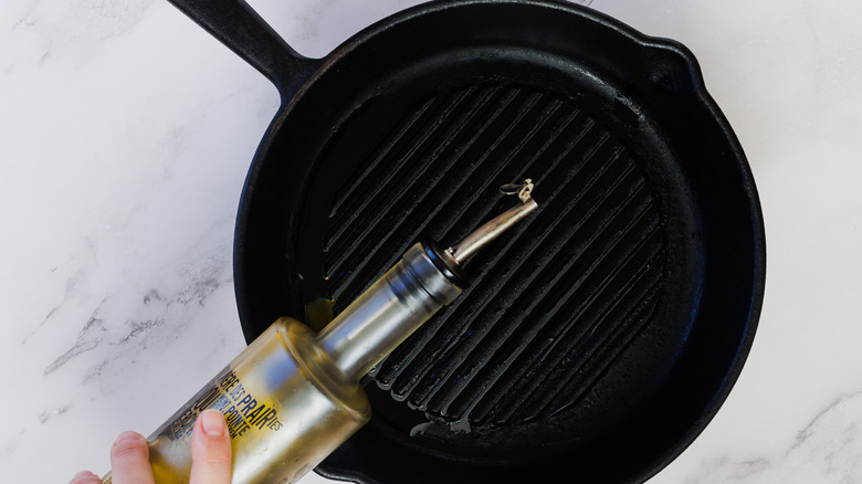 adding oil to cast iron pan