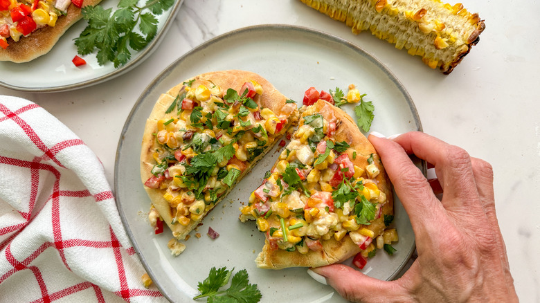 hand holding flatbread on plate