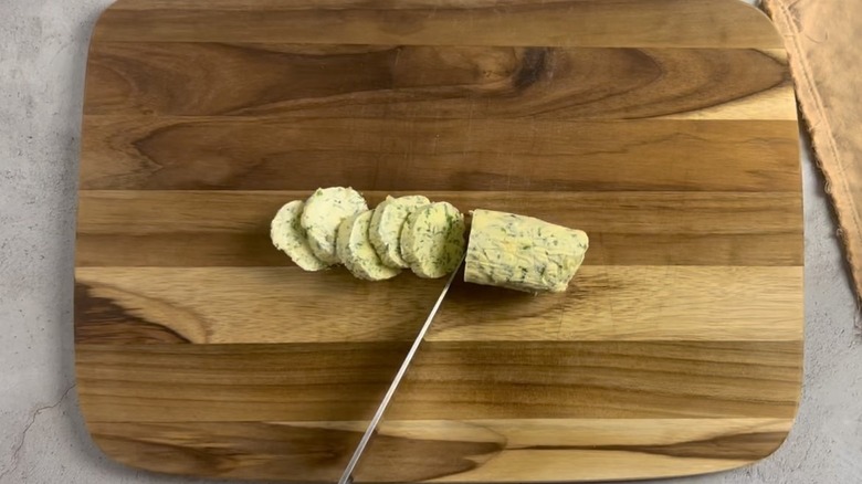 compound butter with knife on cutting board