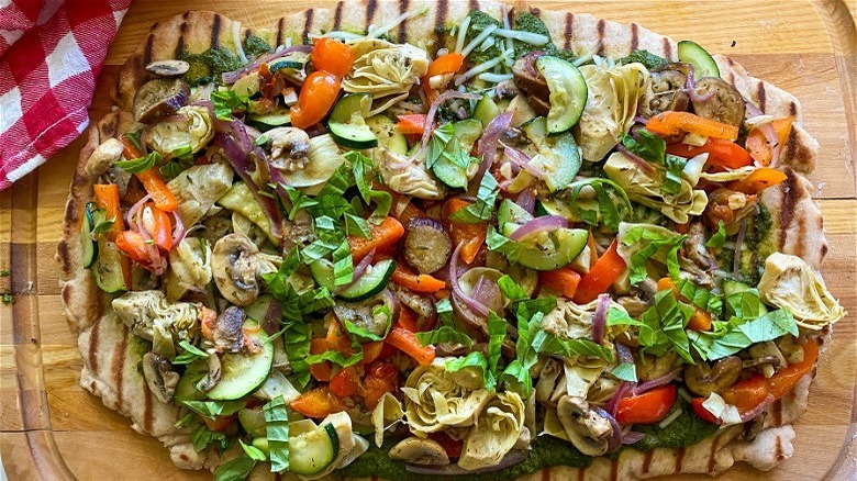 cooked pizza on cutting board