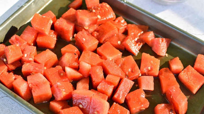 A metal tray filled with cubed pieces of grilled watermelon