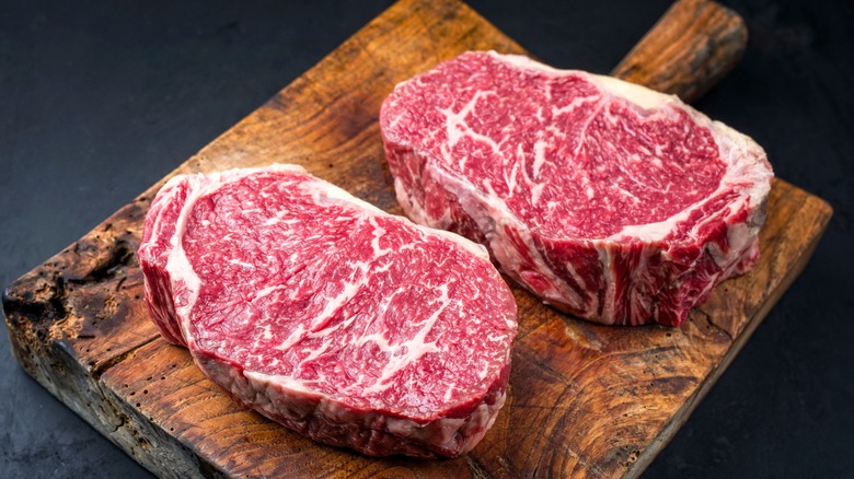 marbled steaks on cutting board