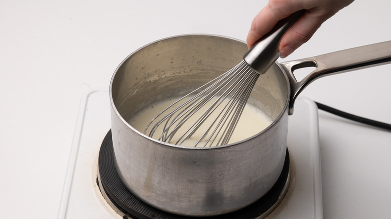 whisking béchamel in a saucepan