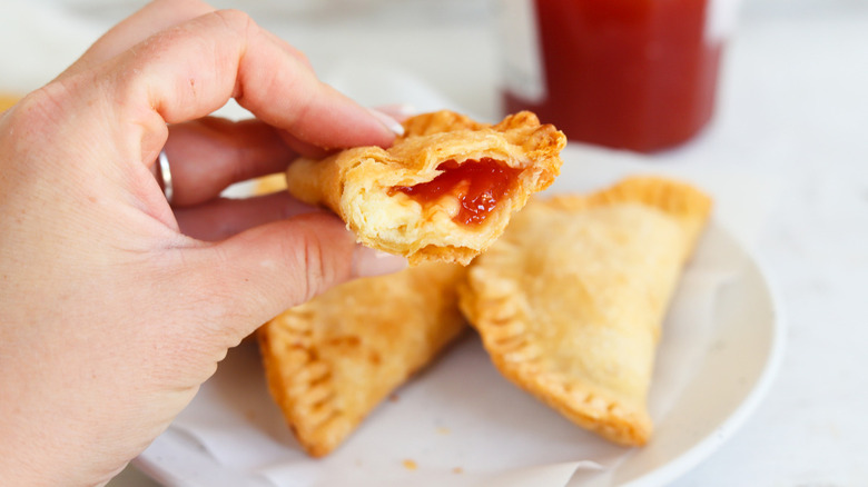 hand holding jam-filled empanada