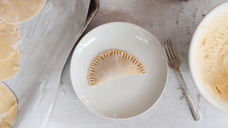 uncooked empanada on white plate