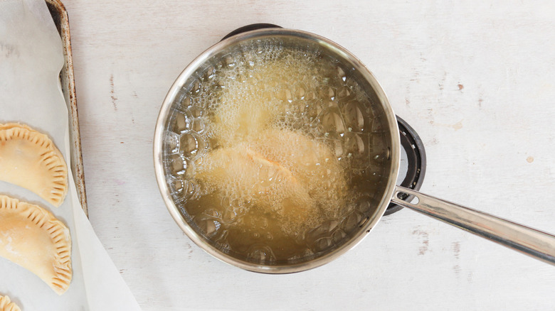 empanadas and oil in pot