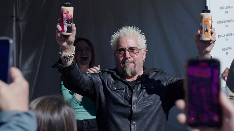 Guy Fieri squeezing sauce from bottles