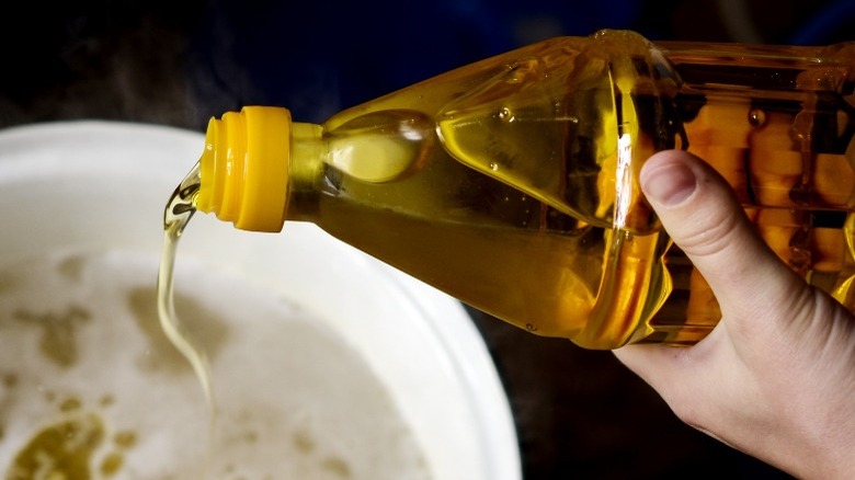 pouring oil into boiling water