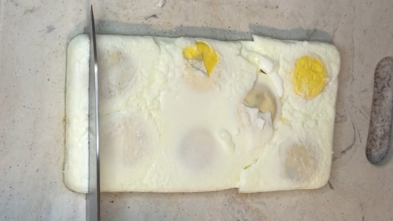 slicing slab of cooked egg