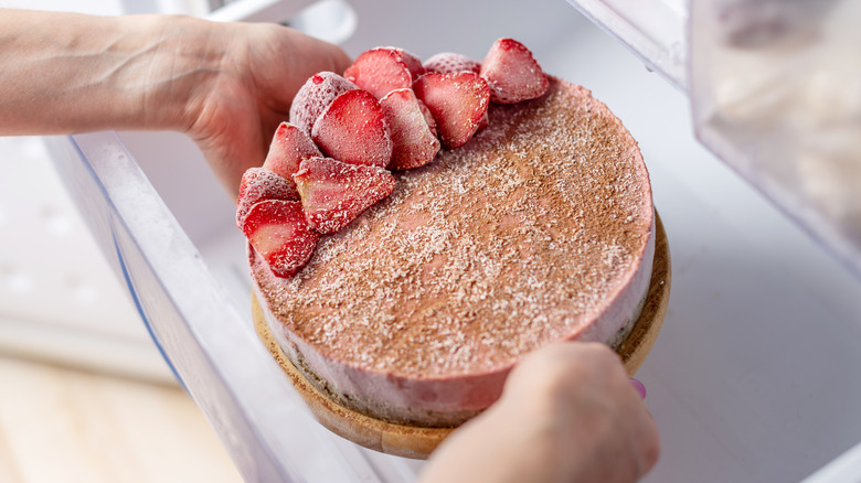 placing decorated cake in freezer