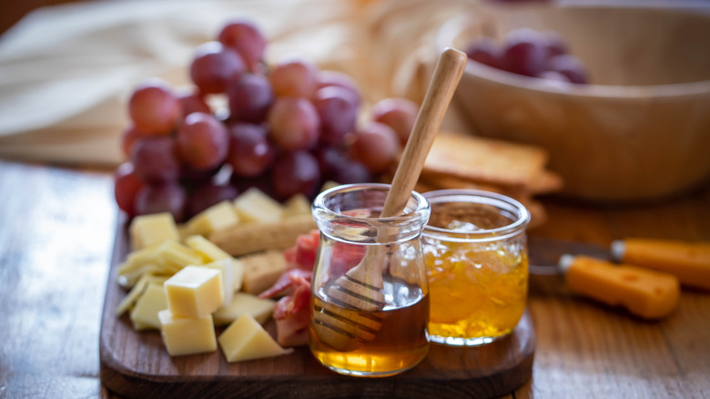 cheese board with grapes and honey
