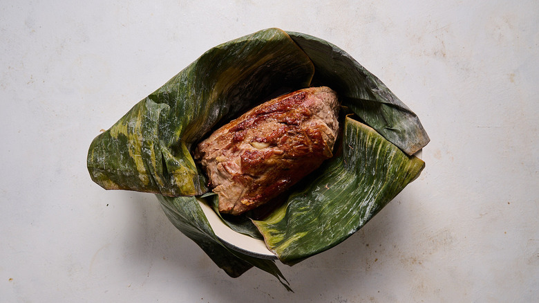 preparing kalua pork with banana leaves