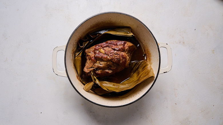 oven braised kalua pork with banana leaves in pot