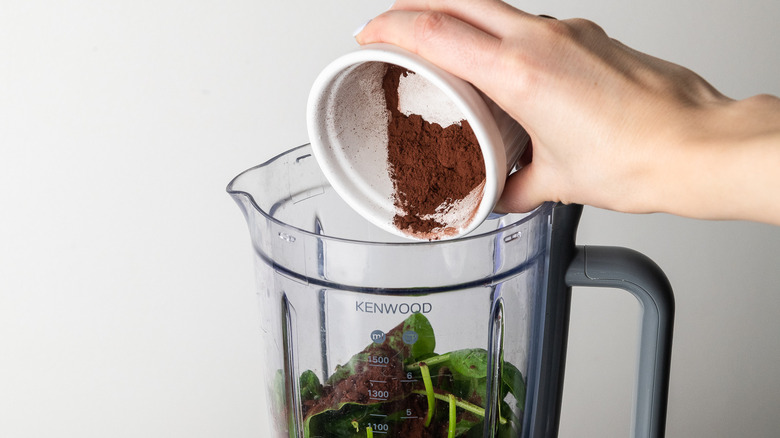 adding cocoa powder to a blender