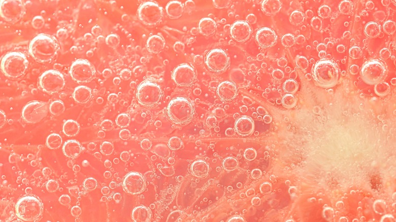 A closeup of bubbles in sparkling grapefruit juice