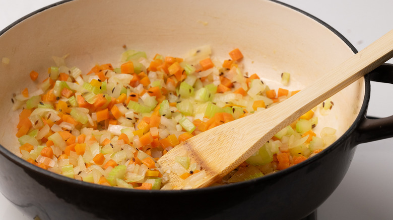 sautéing vegetables in a pan