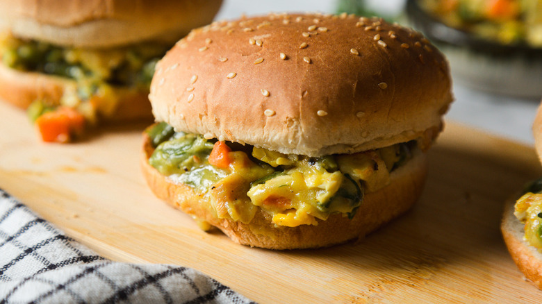 Two chicken pot pie burgers on cutting board