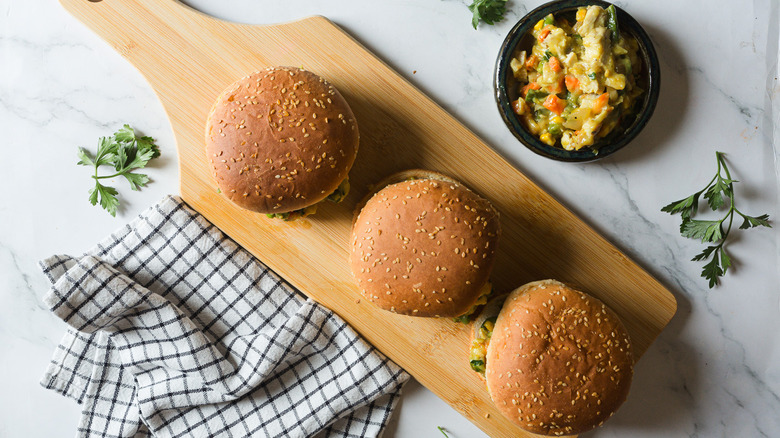 Three chicken pot pie burgers on cutting board