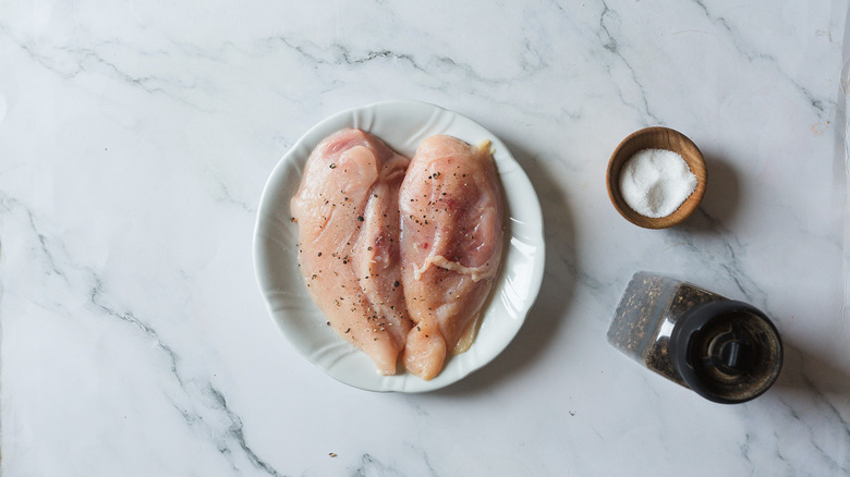 Seasoned chicken breasts in white plate