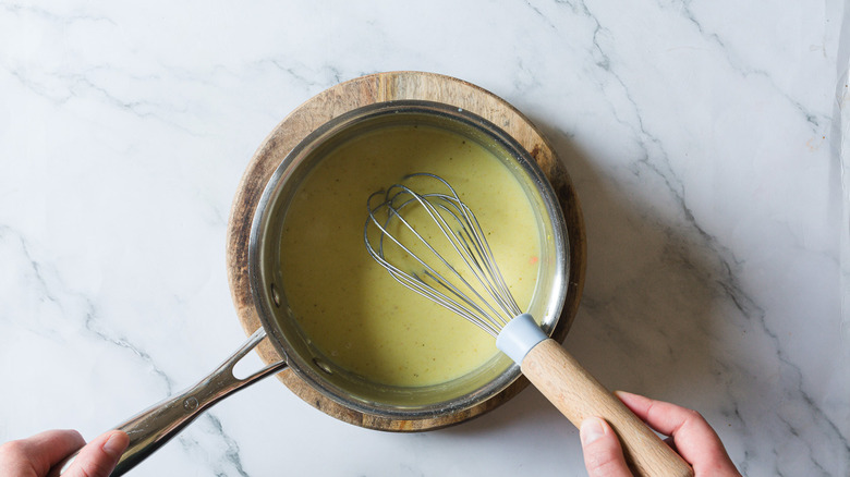 Whisking sauce in saucepan