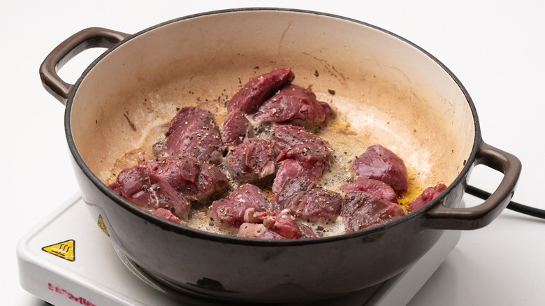 diced venison frying in pan