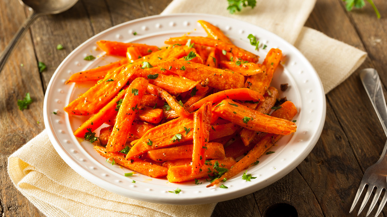 roasted carrots with herbs on white plate