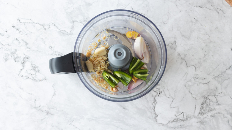 Ingredients and herbs in food processor bowl