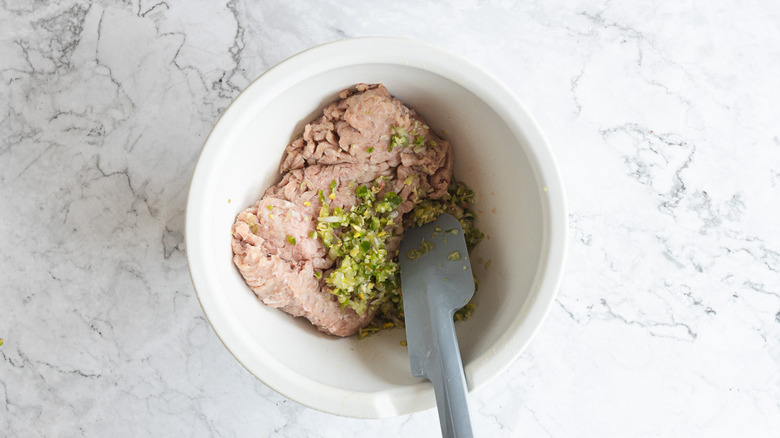 Ground burger mix in bowl with spatula