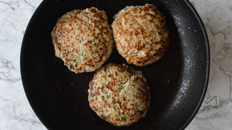 Fried burger patties on pan