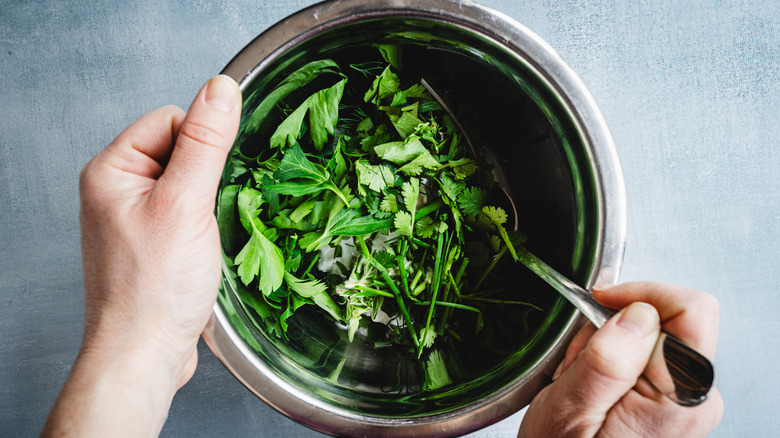 Mixing herbs and yogurt in bowl