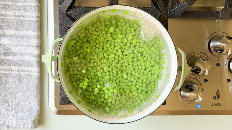 Cooking fresh peas in pot of water