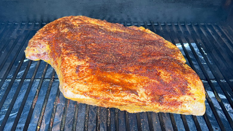 Raw brisket on a grill